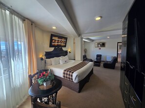 A hotel room with a bed, a desk, a chair, a TV, and a view of the outside. - TerraMistica - Puno Centro (Puno)