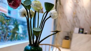 A green vase with flowers on a wooden table. - Aodai Inn Saigon (Ho Chi Minh City)