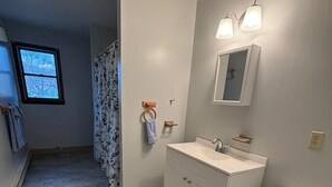 Un baño con inodoro, lavabo y cabina de ducha.