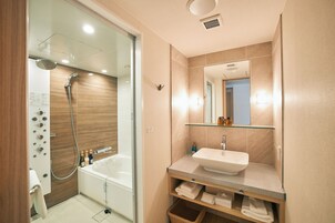 A modern bathroom with a glass-enclosed shower, a standalone bathtub, and a vanity with a mirror.