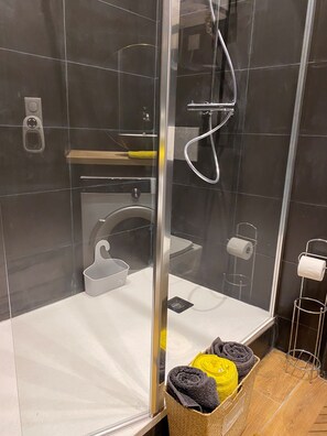Een douche, handdoeken, toiletpapier