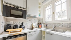 Una cucina moderna con lavastoviglie, forno a microonde e un tagliere in legno.