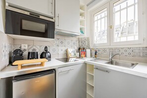 Una cocina moderna equipada con lavavajillas, microondas y tabla de cortar de madera.