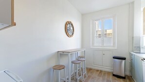 Eine Küche mit weißen Schränken, einem Fenster und einer Holztheke.