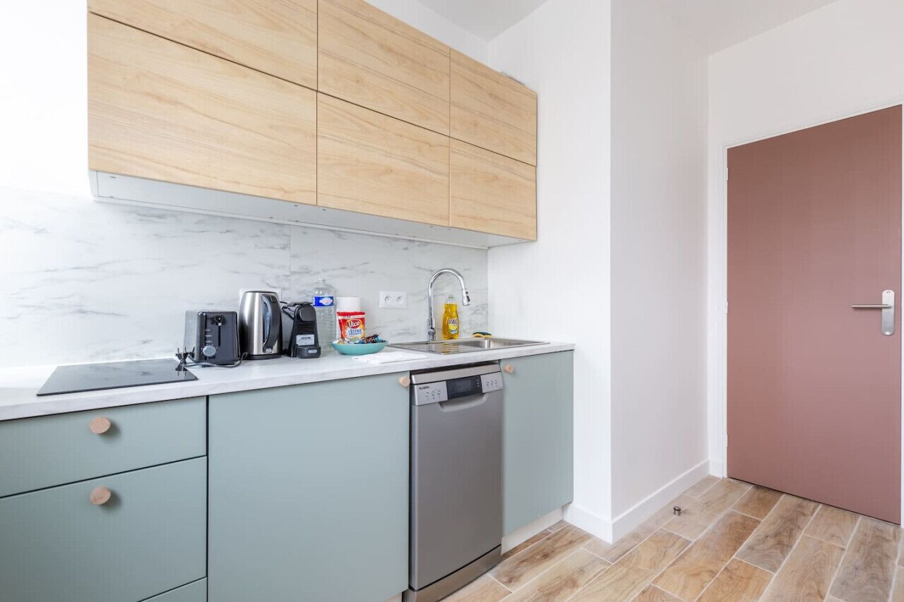 A compact kitchen with a dishwasher, a coffee maker, and a toaster.