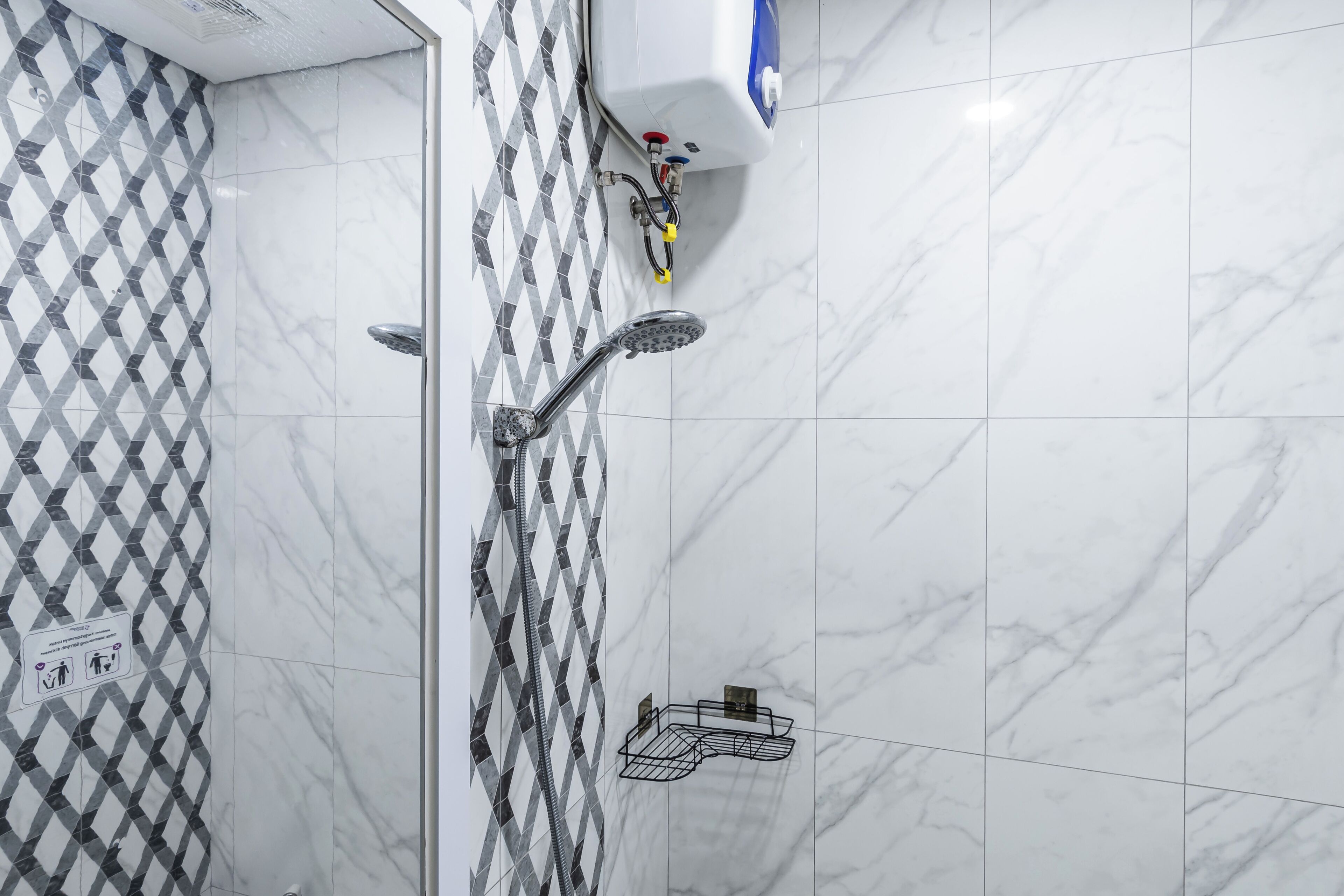 Une salle de bain équipée d’une douche, d’un sèche-mains et d’un porte-serviettes.