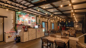 Een restaurant met een marmeren toonbank, zitgedeelte en uitzicht op de stad 's nachts.