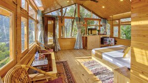 Una cabaña de madera con una cama, una mesa y una silla.