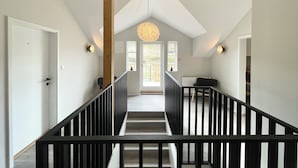 A staircase with black railings leading to a door with a number "4" on it. - Lindarholl Guesthouse (Egilsstaðir)