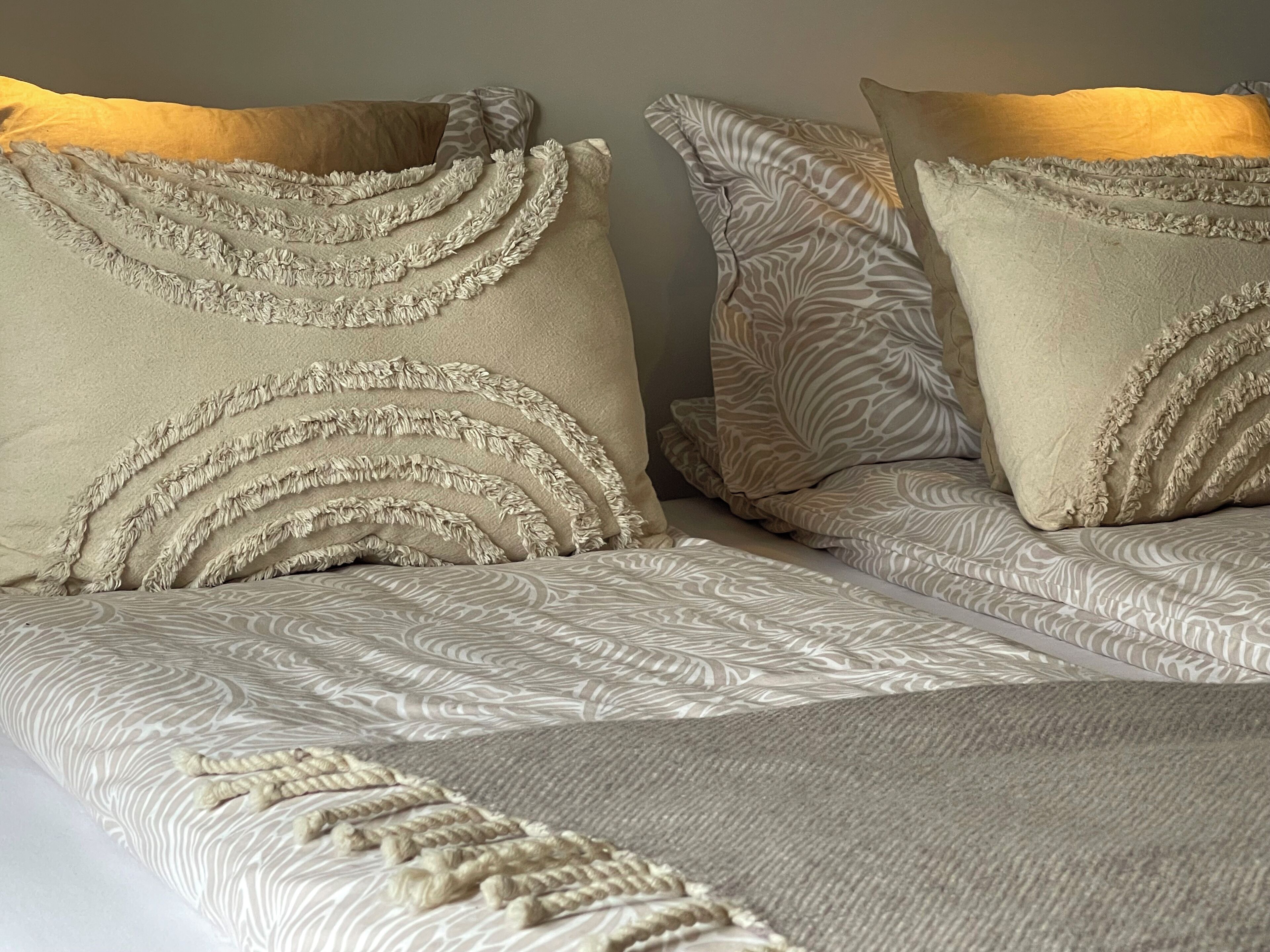 A bed with patterned bedding and decorative pillows.