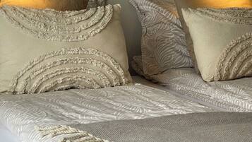 A bed with patterned bedding and decorative pillows.