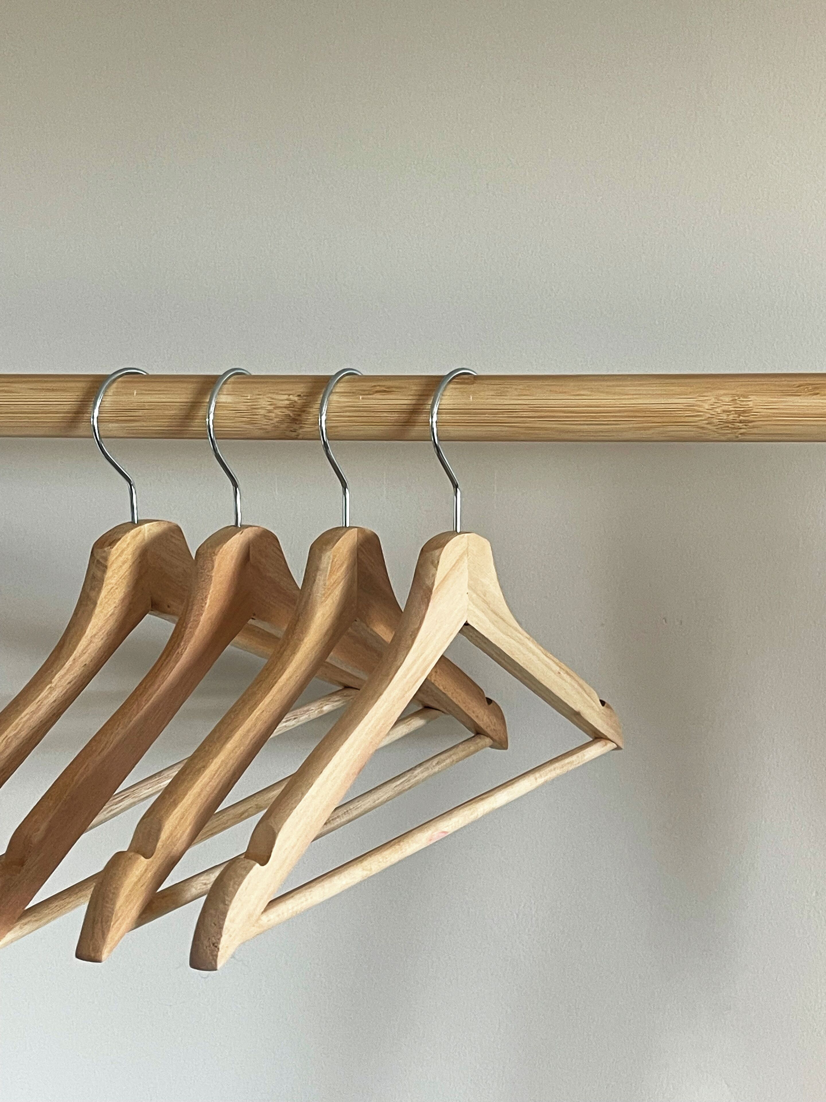 Un perchero de madera con cuatro perchas de madera.