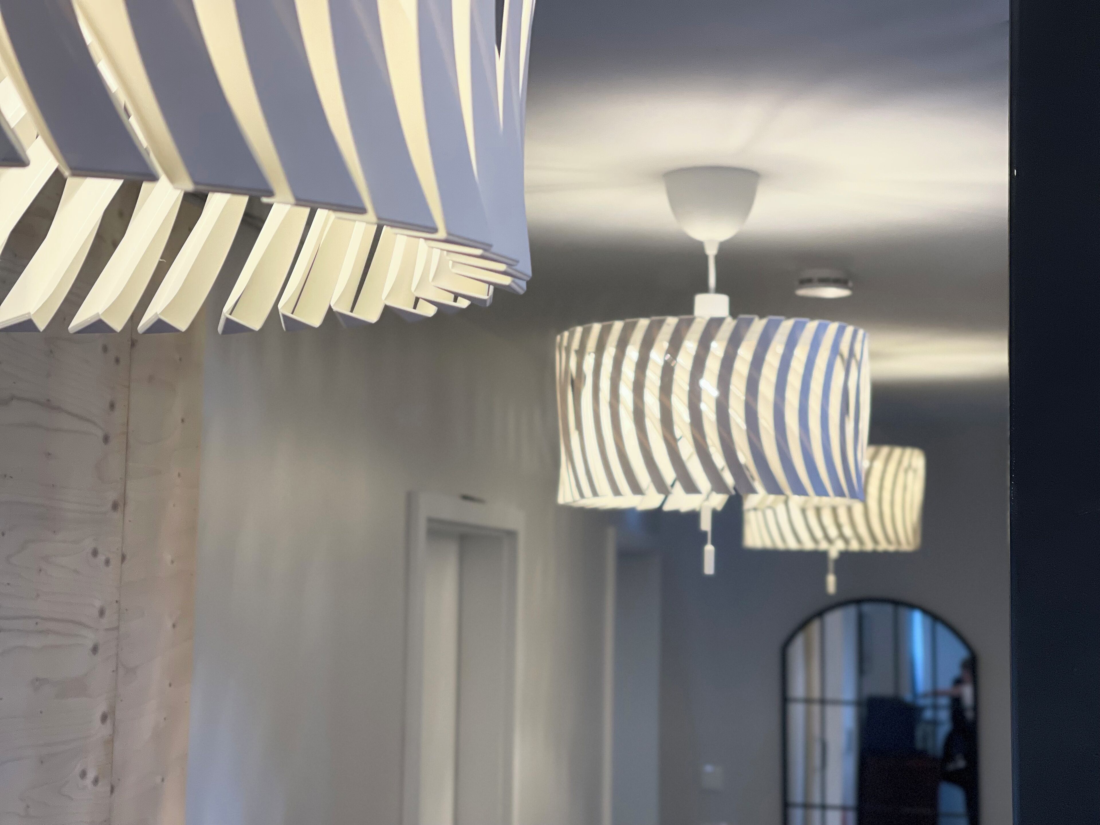 Un corridoio con luci a soffitto moderne e una parete in legno.