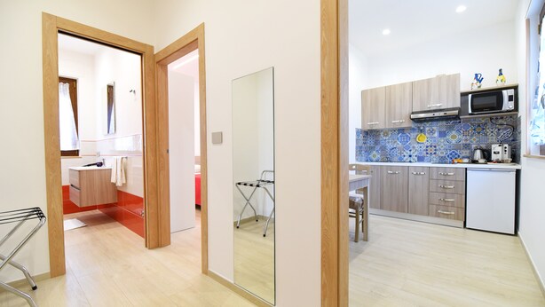 Eine moderne Küche mit Holzausstattung, einer Mikrowelle und einer gefliesten Spritzschutzwand.