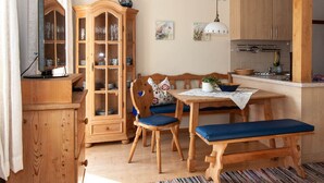 A cozy kitchen with wooden furniture, a dining table, and a cabinet.