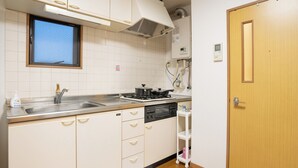 Une cuisine de taille réduite, équipée d’un évier, d’une cuisinière et de placards de rangement.
