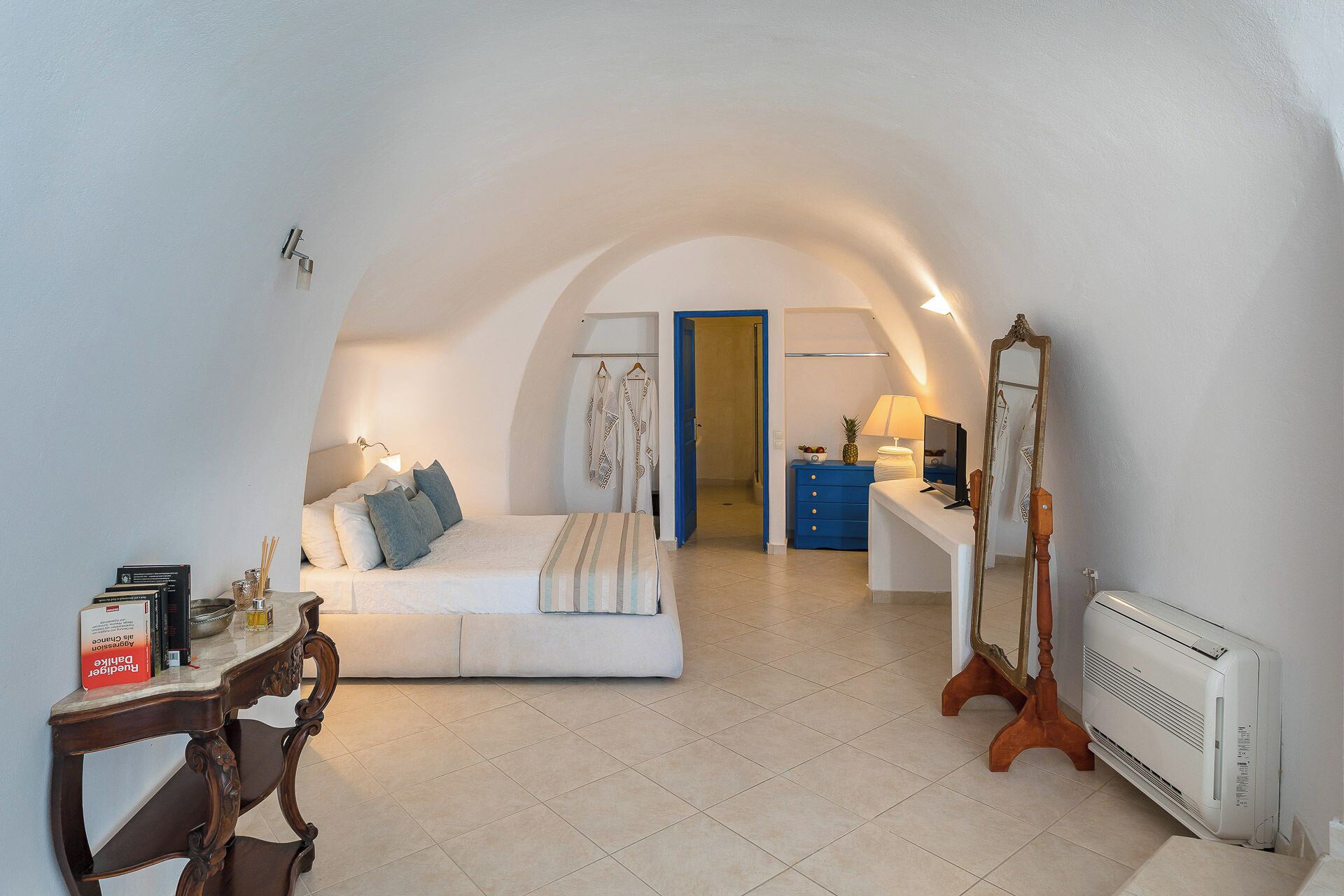 Une chambre à coucher comprenant un lit, un bureau, une commode, un miroir et un radiateur.