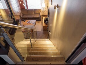 A staircase leading to a living area with a sofa, a coffee table, and a lamp.