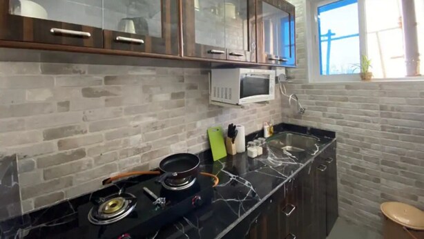 Een keuken met een gasfornuis, een magnetron en een raam met uitzicht.