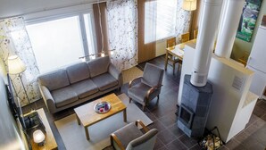 A modern living room with a sofa, armchairs, a coffee table, and a fireplace.