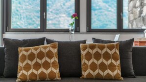 En sofa med mønstrede puder og en vase med en blomst.