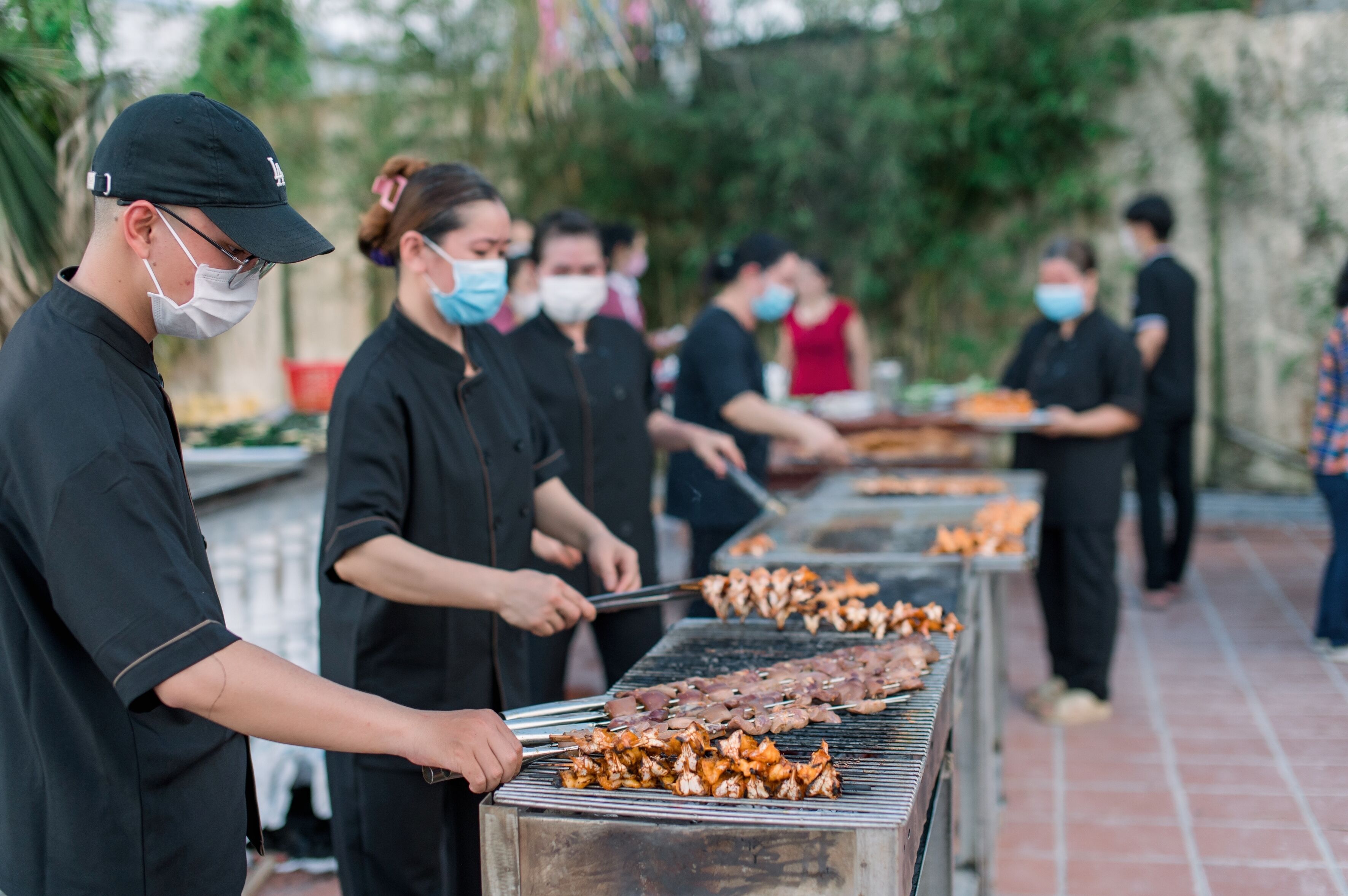 A group of people grilling meat outdoors.
