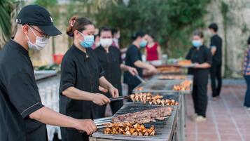 A group of people grilling meat outdoors.