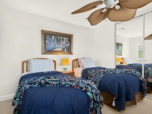 A hotel room with two beds, a ceiling fan, a painting on the wall, and a large mirror. - Fall Sale Rates - Your Vacation Awaits in Ko Olina KoK-1029B (Kapolei)