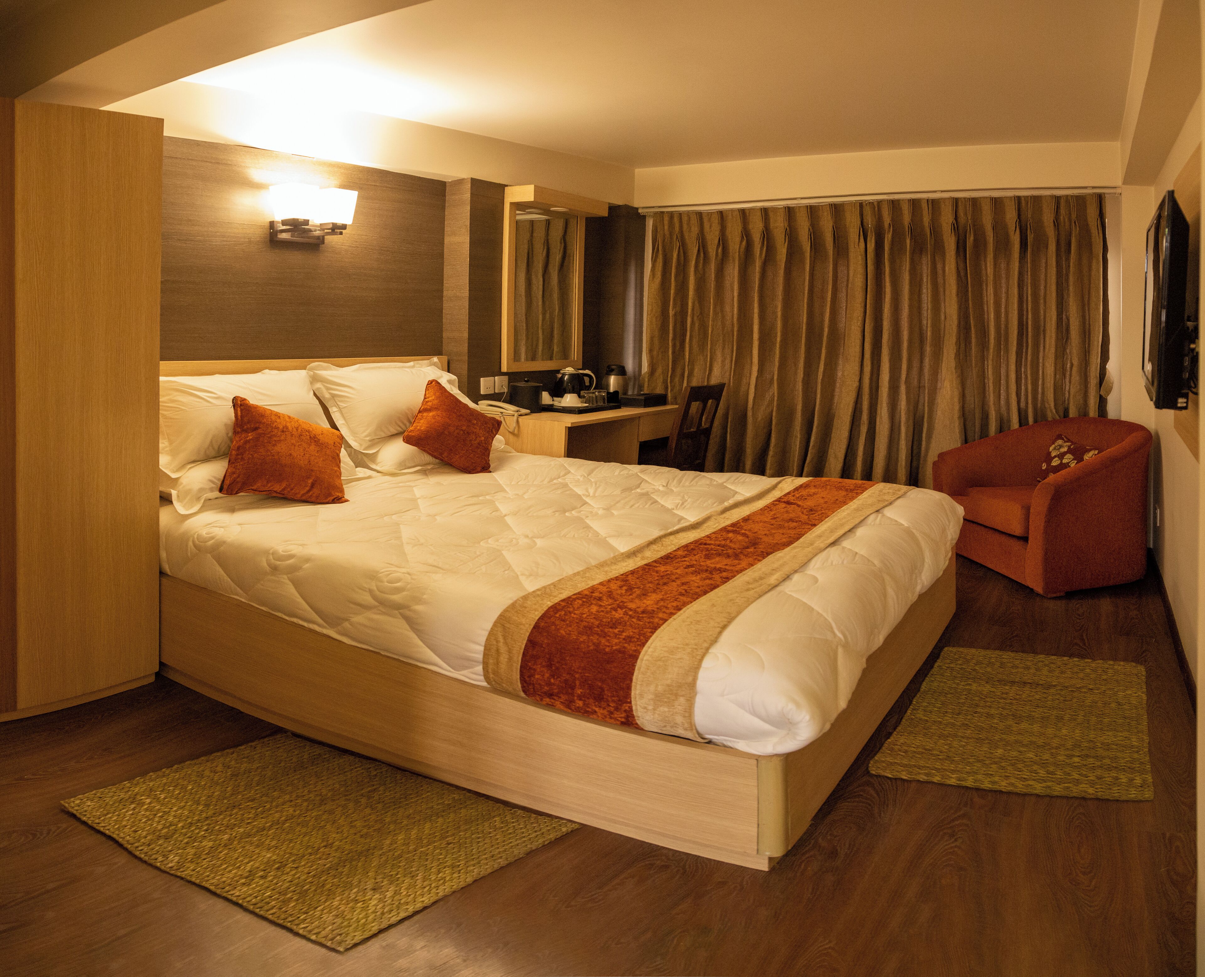 Una habitación de hotel con una cama grande, un escritorio, una silla y un televisor.