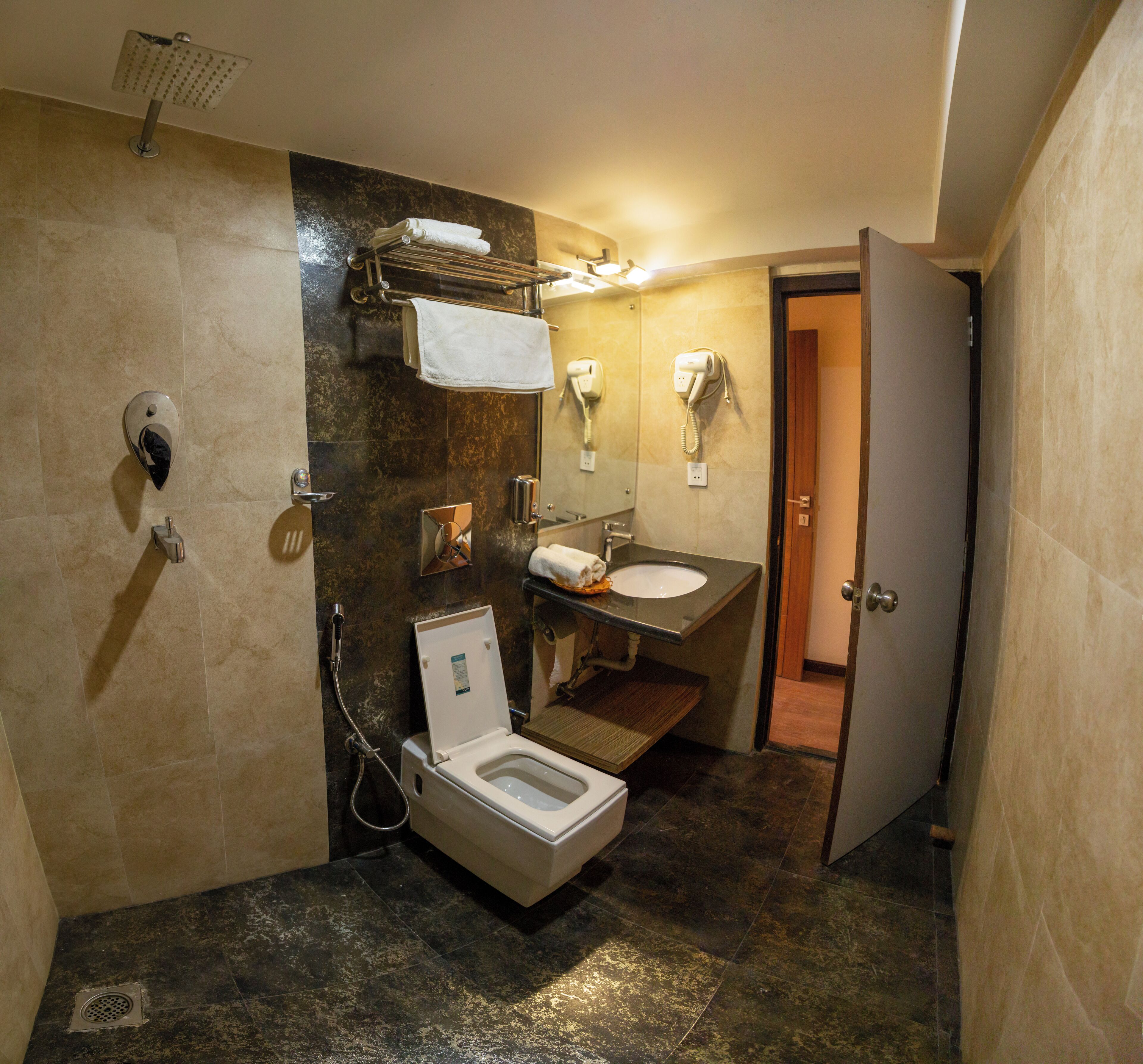 A bathroom with a toilet, sink, towel rack, and a shower.