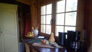 Une cuisine rustique avec des meubles en bois, une grande fenêtre et divers ustensiles de cuisine.