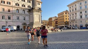A cobblestone square with historic buildings, a central monument, and people walking. - Beautiful Colosseum Roma (Rome)