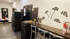 A modern office space with a desk, chairs, a refrigerator, and decorative wall art. - Beautiful Colosseum Roma (Rome)