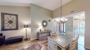 Un espace repas comprenant une table ronde, des chaises, un banc et un lampadaire.