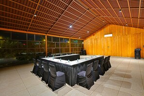 A conference room with a long table, chairs, and a wooden wall. - Soil to Soul Resort - Statue of Unity (Tilakwada)