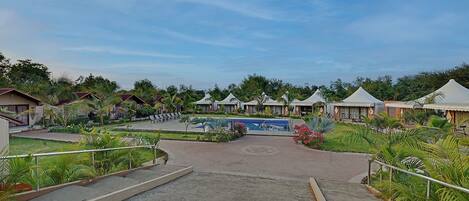 A resort with multiple bungalow-style accommodations, a central swimming pool, and a landscaped garden area.