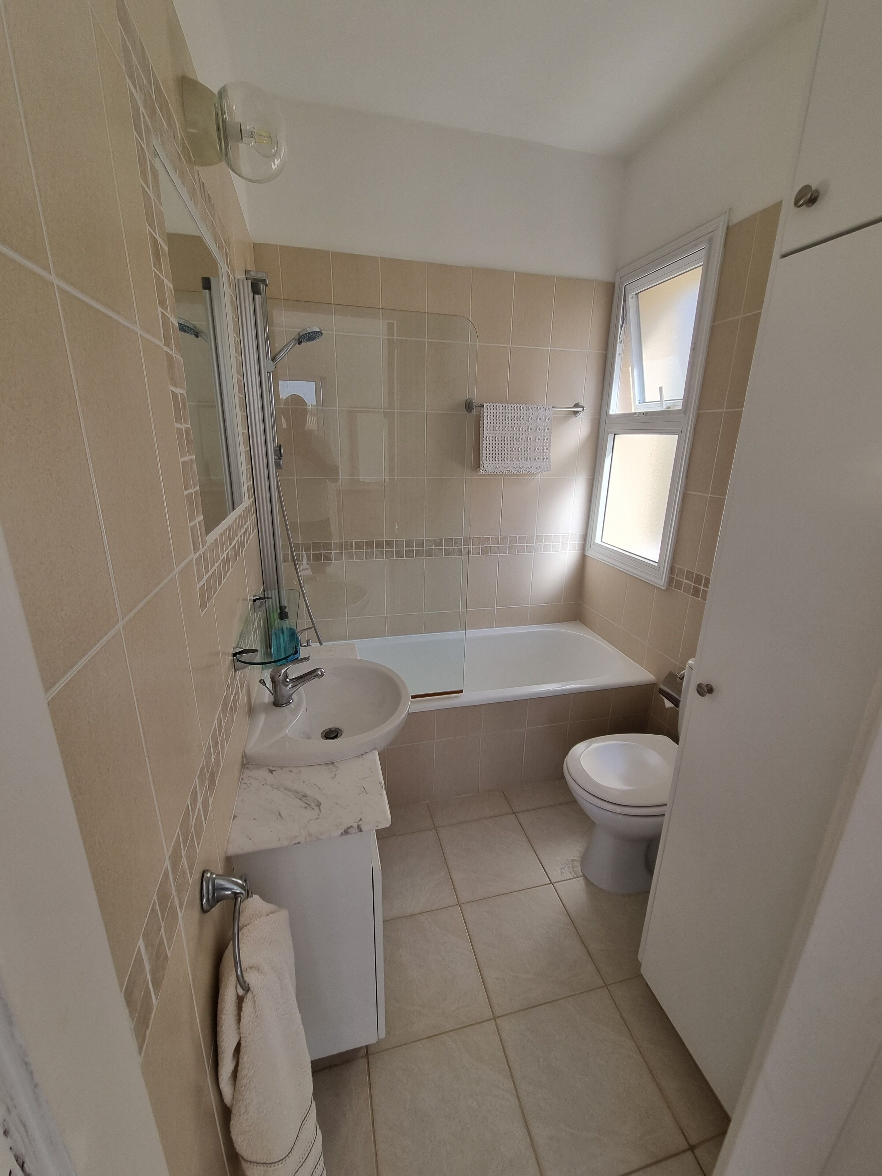 Une salle de bain équipée d’un lavabo, d ’un miroir, d’une douche et de toilettes.