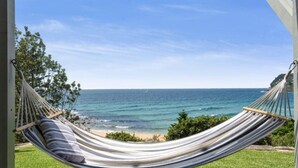 Een hangstoel met uitzicht op zee en strand.