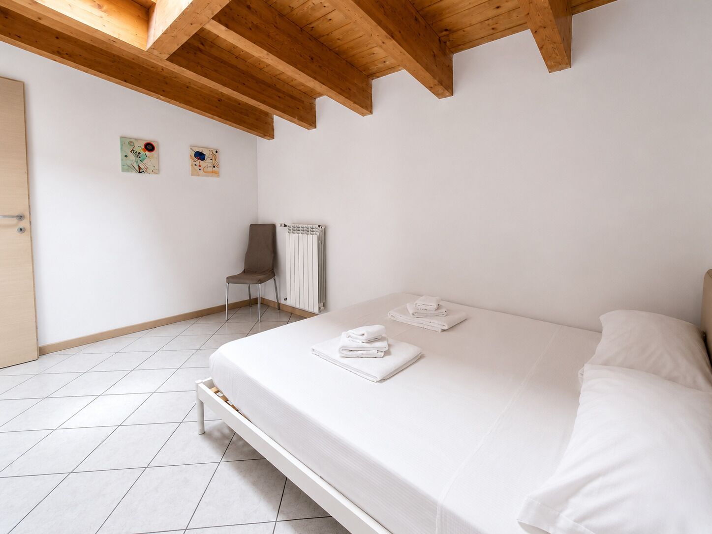 Een slaapkamer met een bed, een stoel en een radiator.
