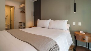 A neatly made bed with a beige throw blanket, a bedside table with a notebook and pen, and a hanging pendant light. - w * | Sensational 2BR in the Heart of Barranco (Lima)