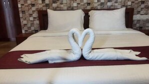 Une chambre d’hôtel avec un lit bien fait, un mur à carreaux et une porte en bois.