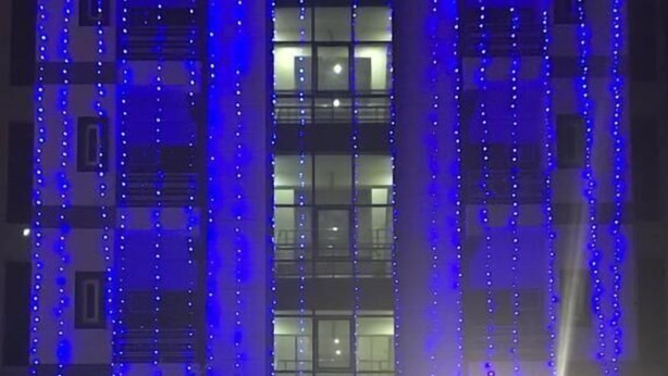 Un bâtiment sur lequel on peut lire l’inscription « MOTEL », avec des néons bleus verticaux et une entrée centrale.