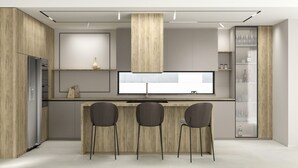 Eine moderne Küche mit einer zentralen Kochinsel, zwei Barhocker und einem Einbaukühlschrank.