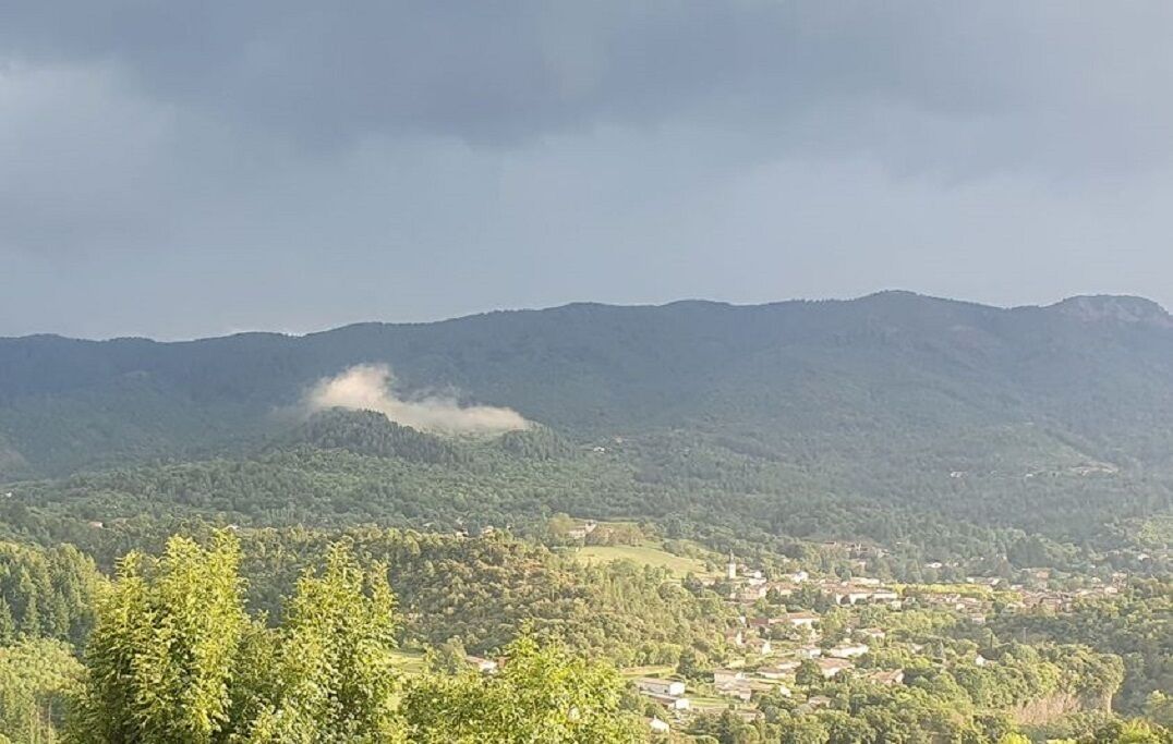 Un paysage montagneux avec un village au premier plan.