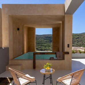 A modern outdoor pool area with a view of a hilly landscape.
