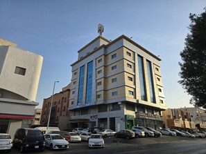A multi-story building with a modern design, featuring a mix of beige and blue facade. - Dar Al Wedad Serviced Apartments (Jeddah)