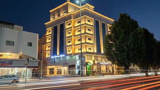 Un hotel de varios pisos con ventanas iluminadas y una entrada destacada.