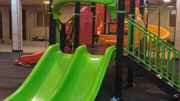Zona de juegos infantiles con toboganes y estructuras para escalar.