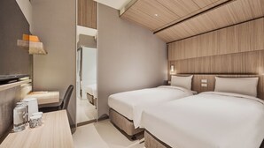 Een moderne hotelkamer met een houten plafond, twee bedden, een bureau met stoel en een spiegel.
