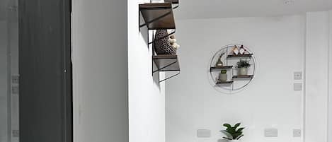 A modern kitchen with white cabinetry, a round dining table, and a potted plant on the windowsill.